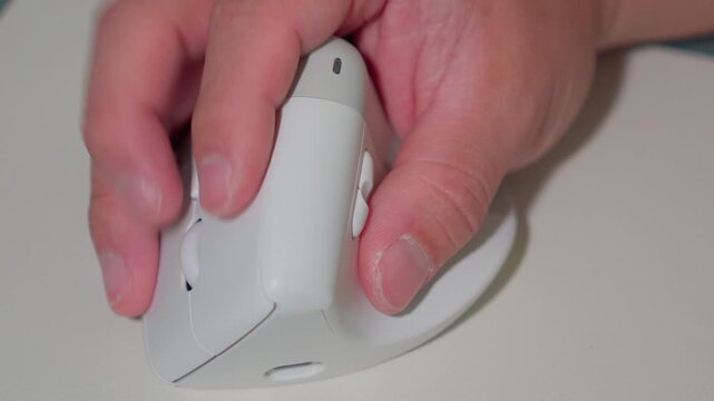 Close Up Man Hand Using Ergonomic Wireless Mouse at Office Desk