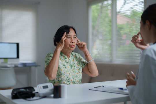 Senior woman discussing headache with doctor during consultation