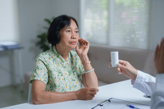 Senior asian woman listening to doctor explaining medication