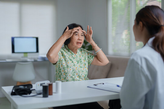 Senior woman discussing headache with doctor during medical consultation