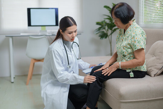 Doctor examining elderly patient knee during house call