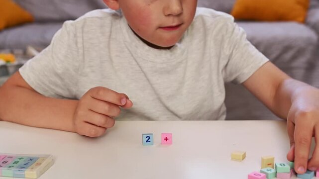 Close Up Child Learning Basic Addition with Colorful Math Blocks, Hand Placing Correct Answer During Early Mathematics Lesson, STEM Education, Homeschooling, Cognitive Development