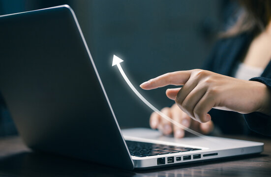 Businesswoman using laptop with a rising digital arrow, symbolizing business growth, financial progress, success, performance, investment strategy, and positive market development.