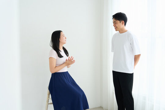 Young Japanese Man and Woman Talking Together in Relaxed Indoor Setting