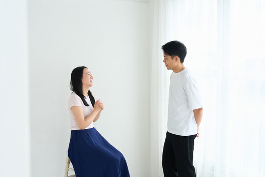 Young Japanese Man and Woman Talking Together in Relaxed Indoor Setting