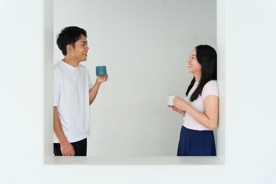 Young Japanese Man and Woman Talking Together in Relaxed Indoor Setting