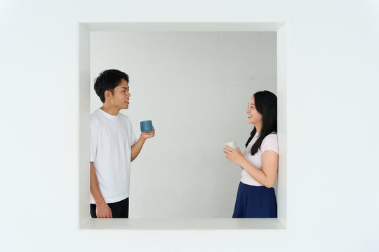 Young Japanese Man and Woman Talking Together in Relaxed Indoor Setting