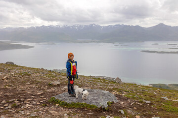 Fototapeta premium Family, hikinh Husfjellet Mountain on Senja Island in northern Norway, bad weather conditions, fog and rain, still enjoying some views over surrounding fjords