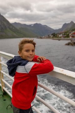 European family, kid with pet dog, enjoying ferry ride between Senja and Andenes Andoya summertime, child and adults on a ferry on sunset