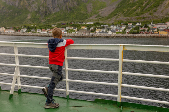 European family, kid with pet dog, enjoying ferry ride between Senja and Andenes Andoya summertime, child and adults on a ferry on sunset