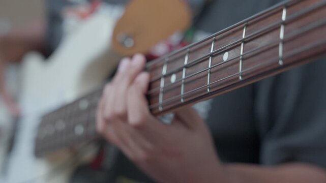 Cinematic Close up of Hand playing Electric Bass Strings During Practice Session