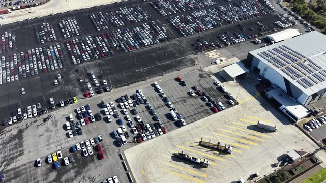 Aerial view of a car carrier truck loading vehicles in a parking lot