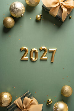 Festive gold 2027 numbers with wrapped gift and ornament for Merry Christmas and Happy New Year on vertical olive color backdrop