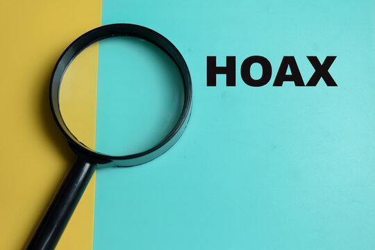Concept of hoax write on color background with magnifying glass.