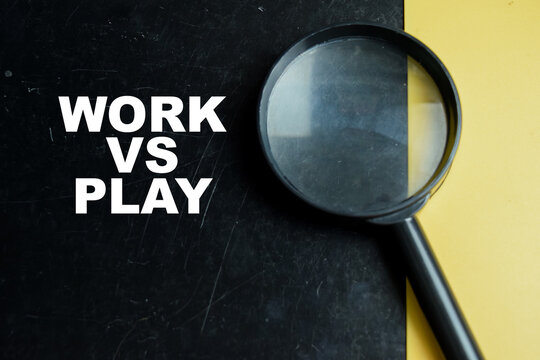 Concept of work vs play write on color background with magnifying glass.