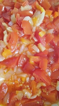 Textured video, seen up close, as the lecs&oacute; (onion, pepper, tomato) cooks in the pot, slightly steaming sometimes.