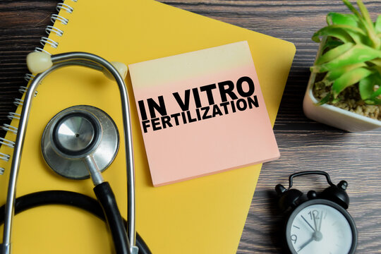 Concept of in vitro fertilization write on sticky notes with stethoscope isolated on Wooden Table.