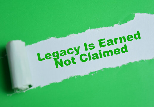 Legacy is earned not claimed text written in torn paper.