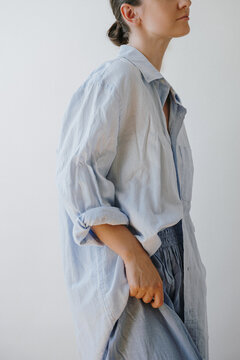 Female Model In Casual Light Blue Button Down Shirt And Matching Trousers Looking Side Way