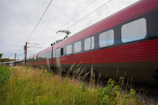 Close Up Low Angle View of Red Danish Passenger Train on Tracks