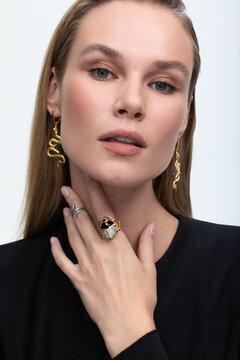 Close up portrait of a beautiful elegant woman with stylish jewelry on a white background. cute girl in black clothes. Beautiful girl with jewelry.