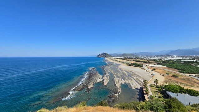 High perspective scenic view of a sprawling sand beach with deep blue ocean water