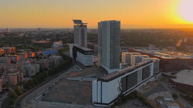 Aerial view of the modern EUR district skyscrapers illuminated by the warm golden hour light in Rome, Lazio, Italy.