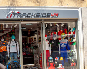 Fototapeta premium Window shop Trackside Lab Storefront with Formula 1 Racing Merchandise store Display in Old Town street. Verona, Italy - June 25, 2026