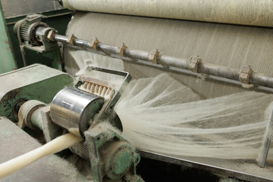 Merino wool slivers spinning on industrial carding machine in factory