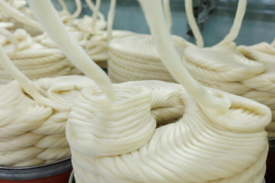 Merino wool slivers feeding into industrial spinning mill cans