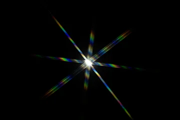 a bright starburst effect with colorful lens flares, often created by photographing a strong light source directly © Roberto Sorin