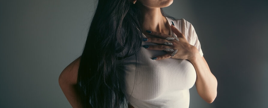Young beautiful woman in a dress posing in a dark room.