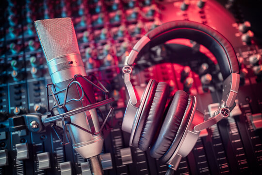 Microphone and headphones on mixing desk in recording studio background concept for podcast, music or presentation