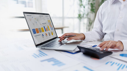 Confident business point to graphs and charts to analyze market data, balance sheet, account, net profit to plan new sales strategies to increase production capacity. © groviapoto
