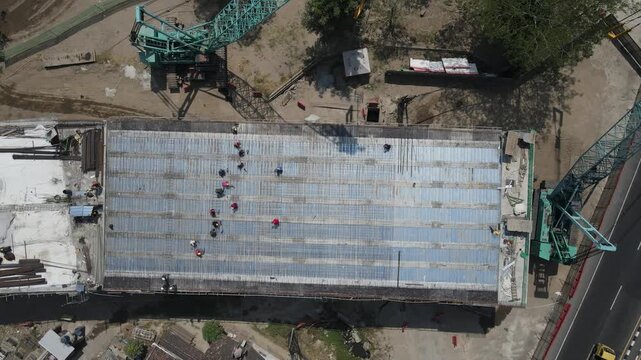 Aerial view of a large crawler crane at a bridge for flyover girder construction site construction site with workers and cranes in Yogyakarta, Indonesia.
