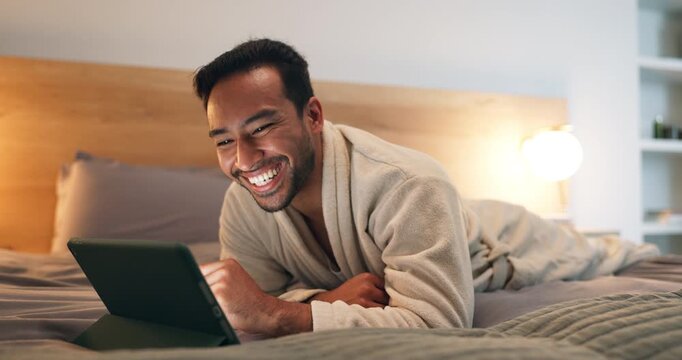 Man, laugh and relax in bedroom with tablet, funny comedy video and online entertainment at night. Late, happy person rest and browsing in home with tech, social media joke or humor for internet meme