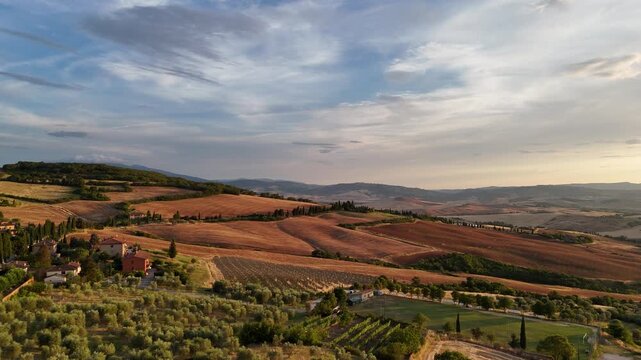 Aerial panorama of rolling Tuscan fields at golden hour in Italy