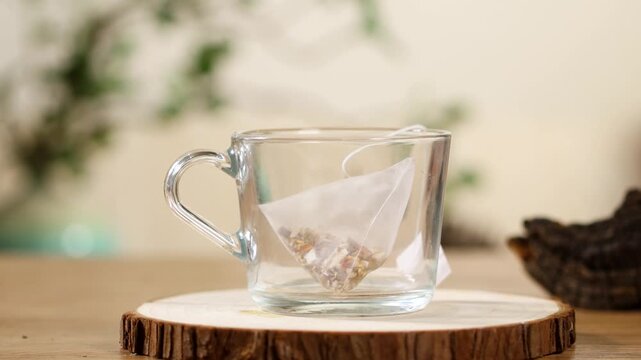 Pouring Hot Water into Glass Cup with Tea Bag