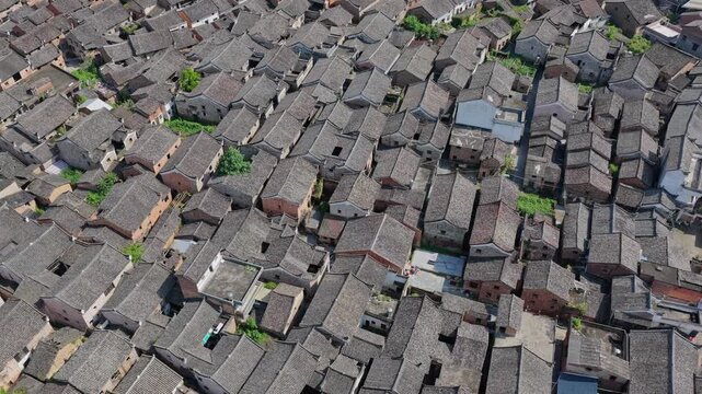 Aerial view of the historic Shanggantang Ancient Village featuring dense traditional grey-tiled rooftops and narrow alleys in Yongzhou, Hunan, China.