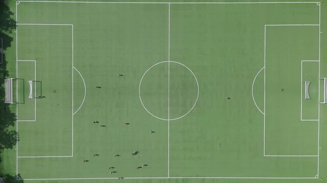 Aerial view of a soccer field with players training on the green pitch in Gdansk, Poland.