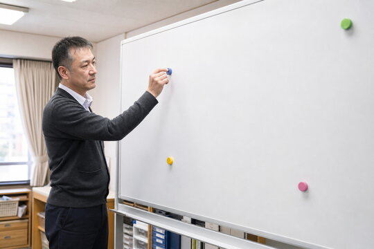 無地の磁石で休暇中の担当体制を準備する男性管理者