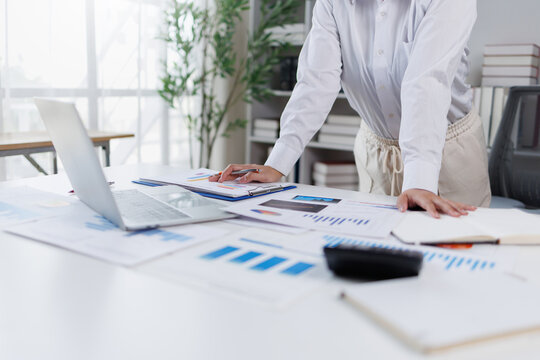 Business woman analysis summary graph reports of business operating expenses and work data about the company's financial statements.