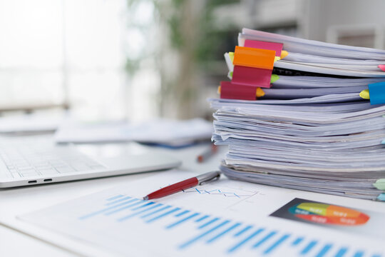 Stack of Business Documents and Financial Reports with Colorful Clips on Office Desk