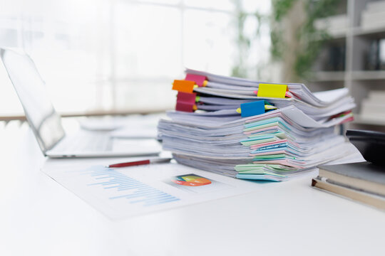 Stack of Business Documents and Financial Reports with Colorful Clips on Office Desk