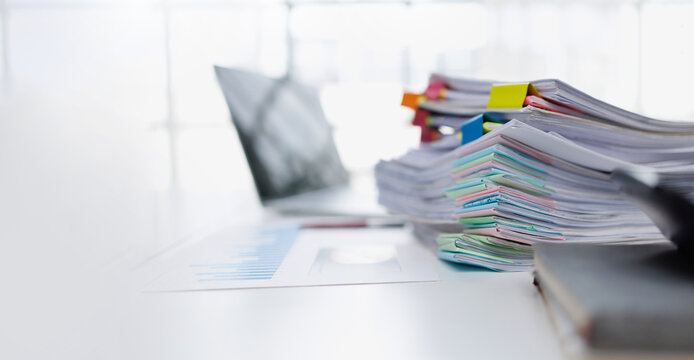 Stack of Business Documents and Financial Reports with Colorful Clips on Office Desk