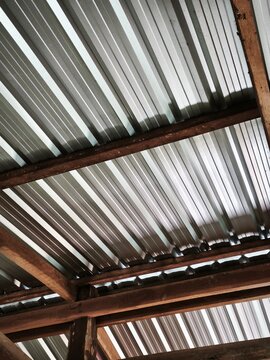 Corrugated Zinc Roof Structure Underneath View with Rustic Wooden Beam Frame Construction