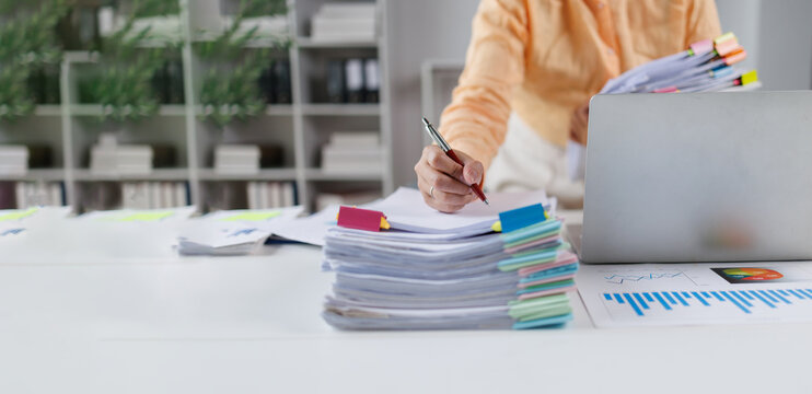 Businesswoman organizing financial documents and reports on office desk Financial Documents and Files in Office