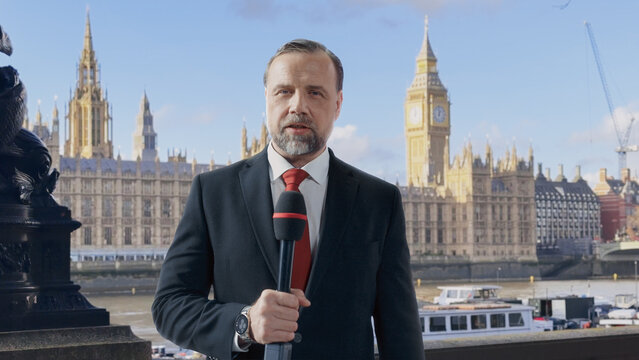 Male TV Reporter Delivers a Financial and Business News, Holding a Microphone With Historic Site in Background. Lower-third Graphics and Scrolling Ticker Headline World News, Politics, Stock Market