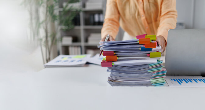 Businesswoman organizing financial documents and reports on office desk Financial Documents and Files in Office