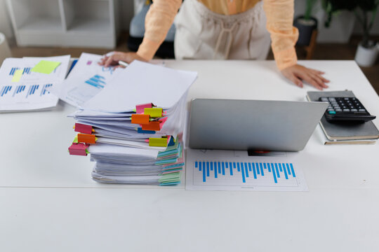 Businesswoman organizing financial documents and reports on office desk Financial Documents and Files in Office